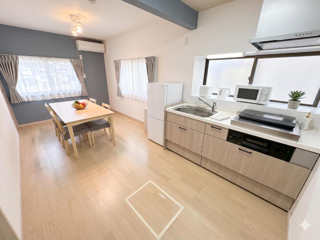 a kitchen with a small table and a kitchen with a refrigerator at EASE-Takasaki-Yawata in Takasaki