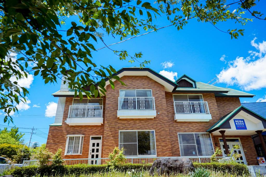 a brick house with a blue sky in the background at REIBA STYLE Hotel in Nagasawa