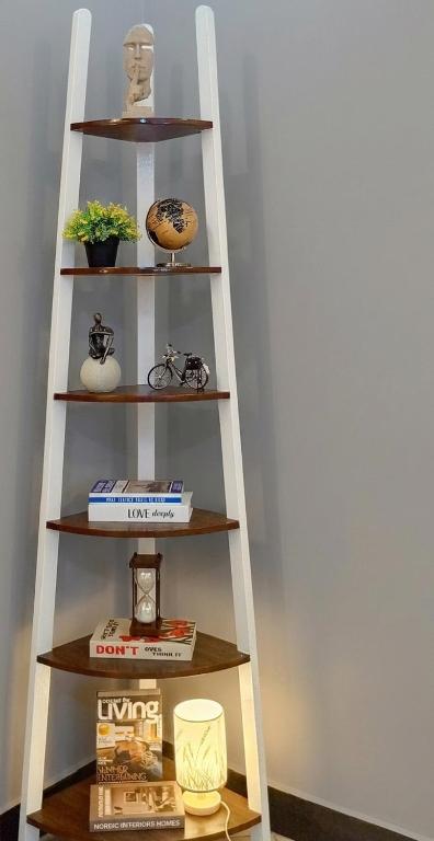a ladder shelf with books and books on it at Dephil stays in Jinja