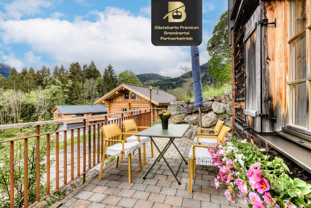 a patio with a table and chairs and a cabin at Chalet Tschengla in Bürserberg