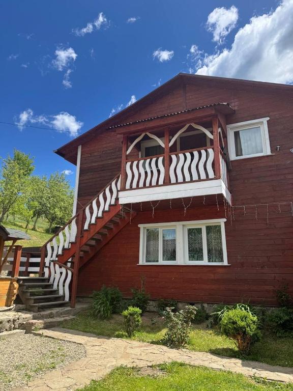a red house with a staircase on the side of it at Hirska Vatra in Slavske