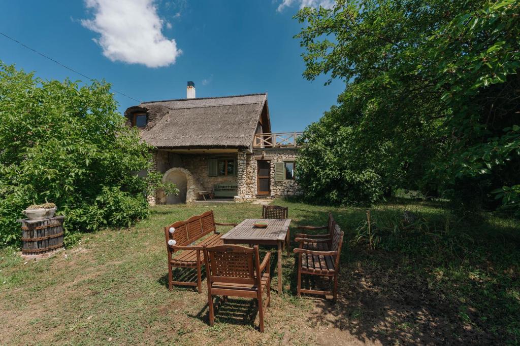 a table and chairs in front of a house at Baglyashegy Vendégház in Sümeg