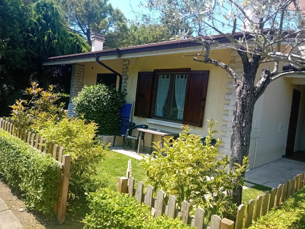 a small yellow house with a wooden fence at La Palma in Sirmione