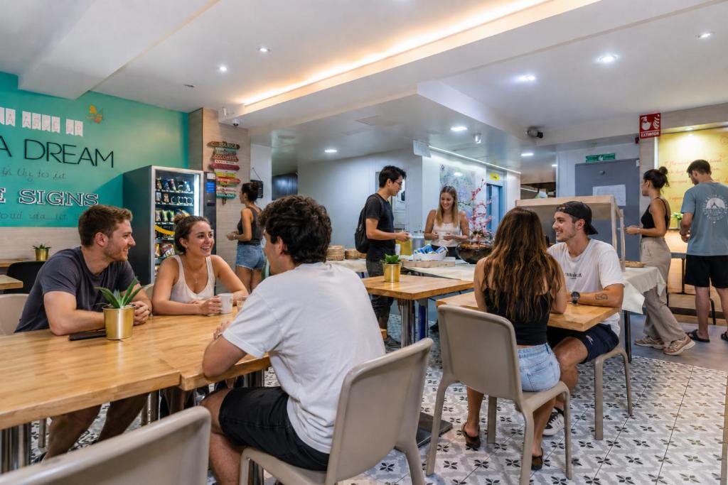 a group of people sitting at tables in a restaurant at Sun & Moon Hostel in Barcelona