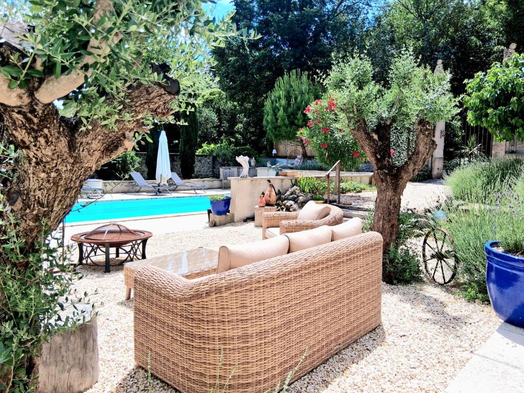 a backyard with a couch and a pool with trees at Le Clos des Troubadours in Pennautier