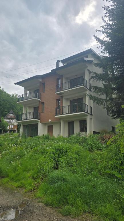 a large apartment building on top of a hill at Pine Apartments Mavrovo in Mavrovo