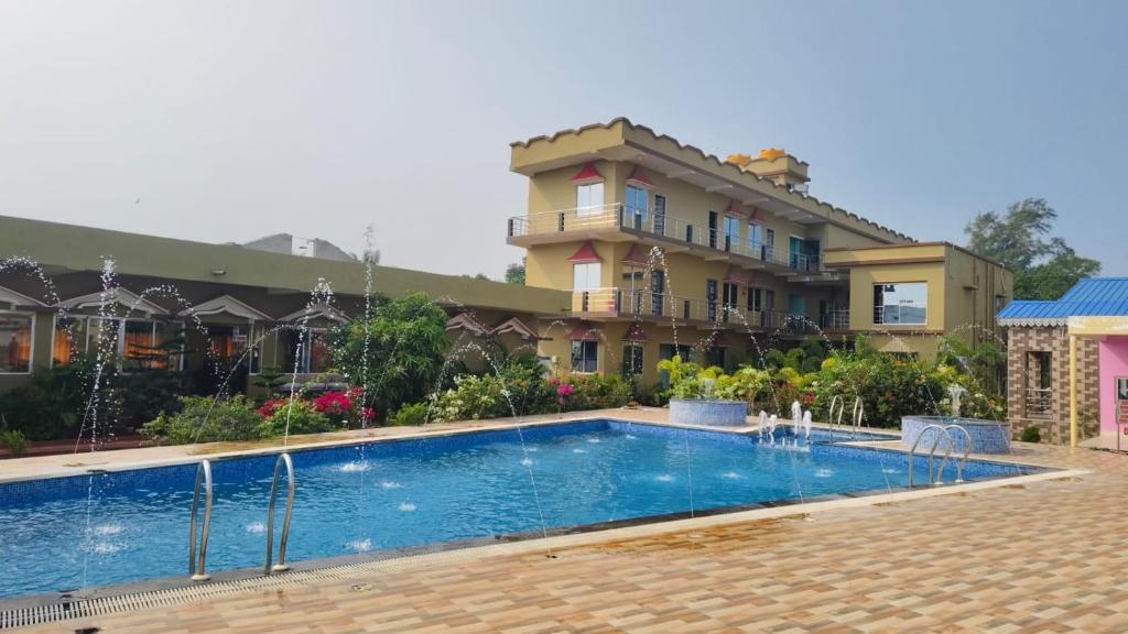 a hotel with a swimming pool in front of a building at RESORT SAIKAT SARANYA in Mandarmoni