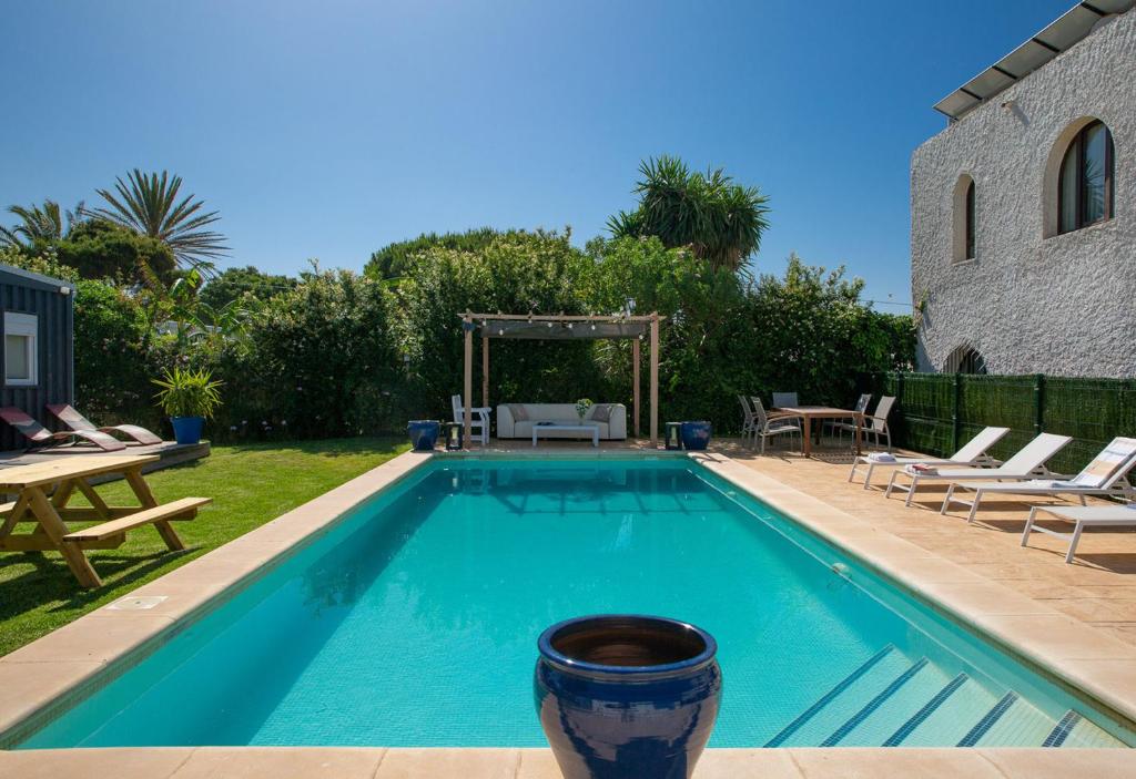 a swimming pool in a yard with chairs and a table at Apartamentos Zahora 37 in Zahora