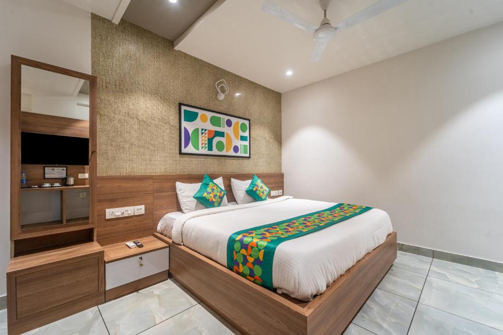 ein Schlafzimmer mit einem großen Bett und einem Spiegel in der Unterkunft Treebo MR Motel, 10 Mins To Airport in Mattanūr