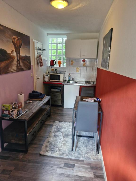a kitchen with a wooden table and a table and chairs at Apartment 4 nähe Elmshorn Barmstedt in Bokholt-Hanredder