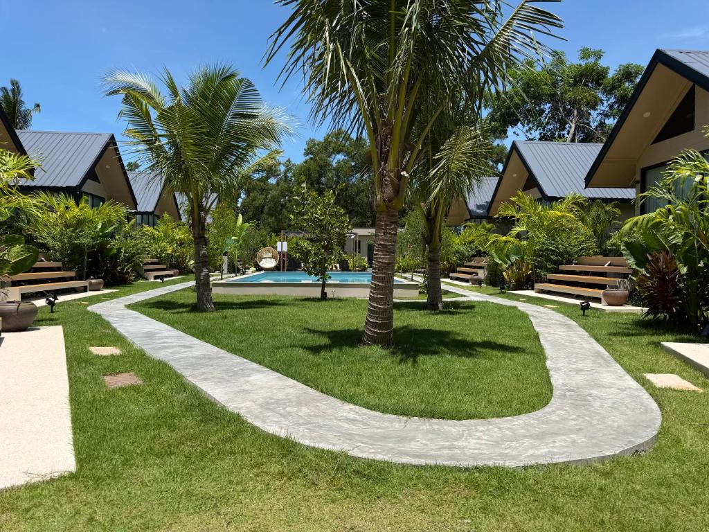 a walkway in front of a resort with palm trees at Good Mood Bungalows in Ko Phangan