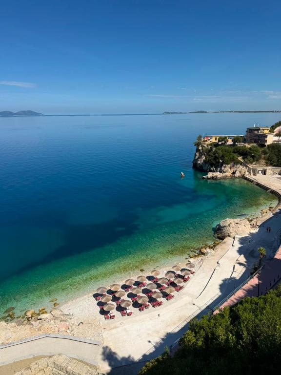 an aerial view of a beach with umbrellas and the water at Skyhill Rooms and Suites in Vlorë