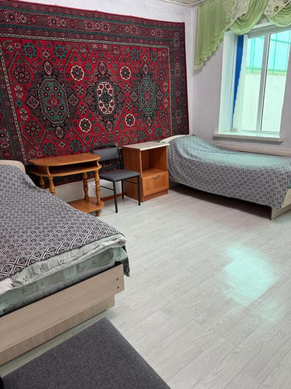 ein Zimmer mit zwei Betten und einer roten Wand in der Unterkunft Arnas in Barskoon