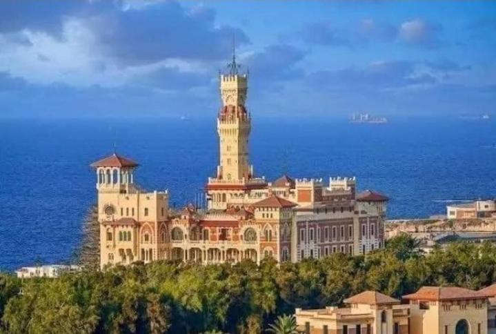 a large building with a clock tower on top of it at Smouha Zahran Haus for Private rooms or Private Apartment in Alexandria