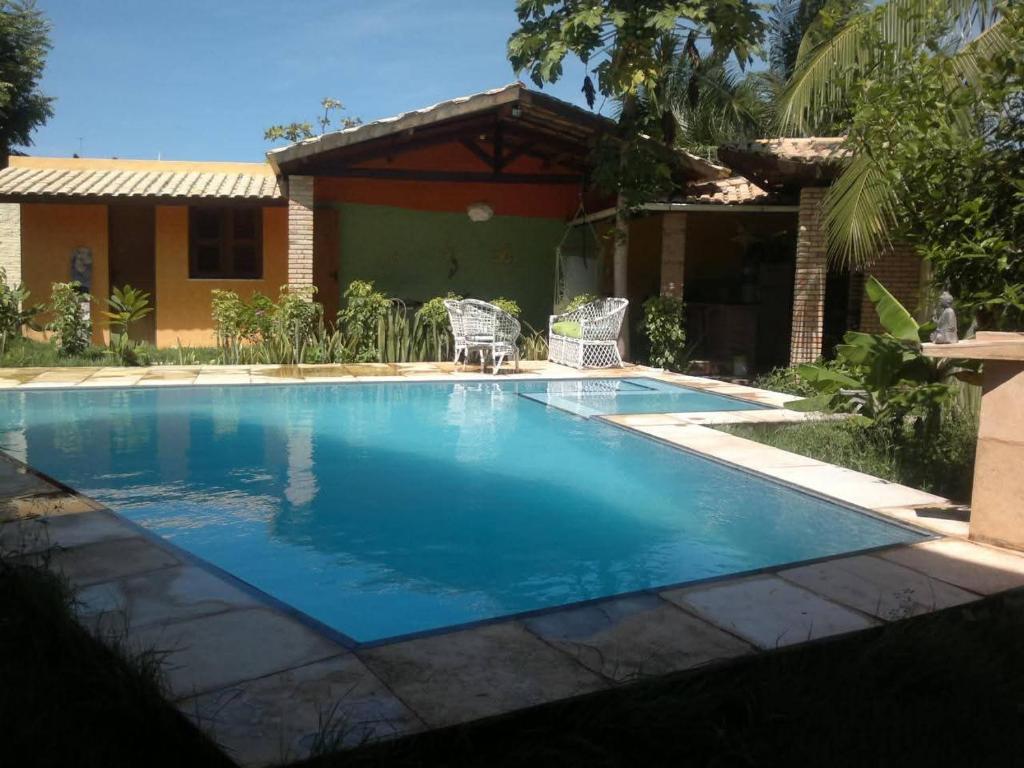 a swimming pool in front of a house at Châle guesthouse in Paracuru