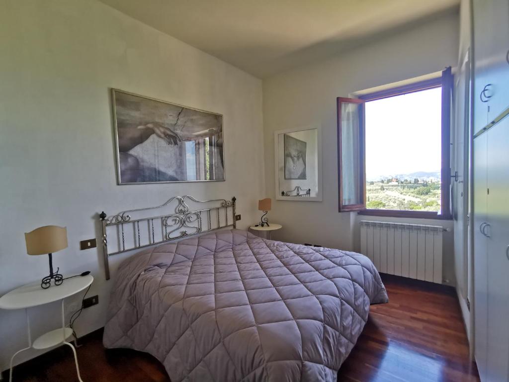 a bedroom with a bed and a window at Mezzomonte View in Impruneta