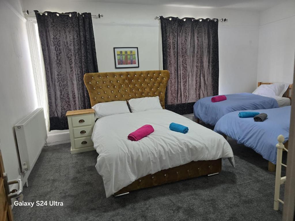 a bedroom with two beds with purple and red pillows at J & T property in Great Coates