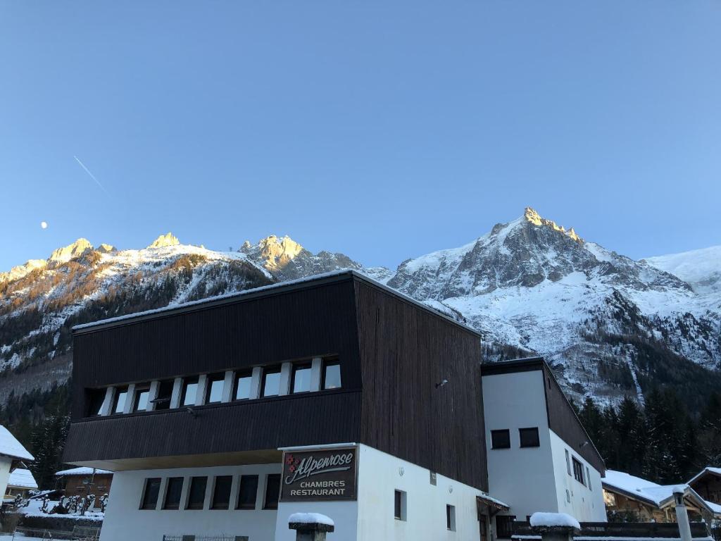 a building with snow covered mountains in the background at Alpenrose Chamonix in Chamonix