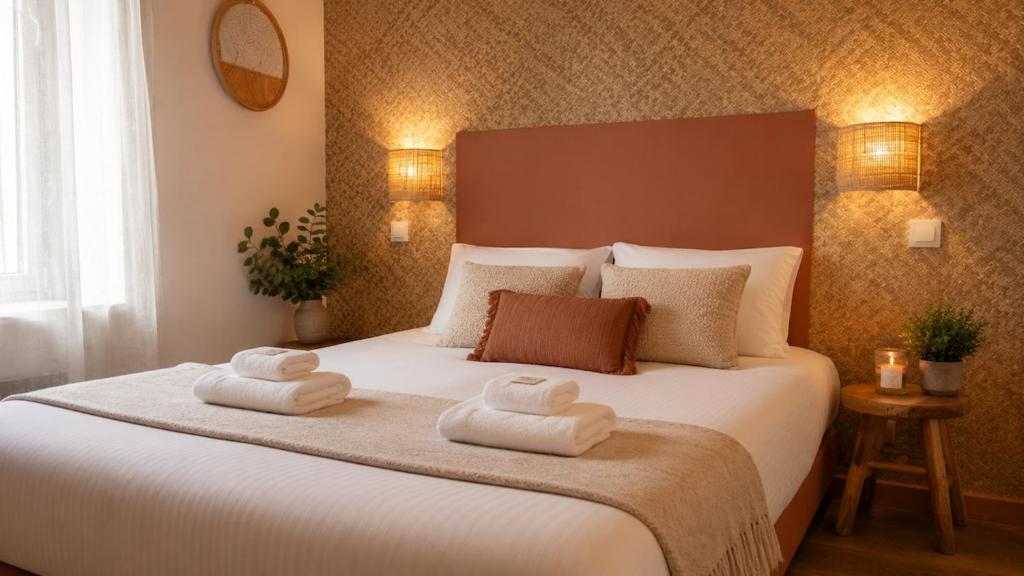 a bedroom with a large bed with towels on it at Oparadi 'L'Authentique' in Wimereux