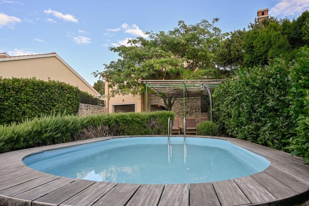 a swimming pool on a wooden deck with a water fountain at House Polic in Hreljin