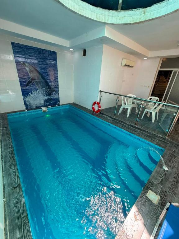 a swimming pool with a fish painting on the wall at شالية الرايس in Rayyis