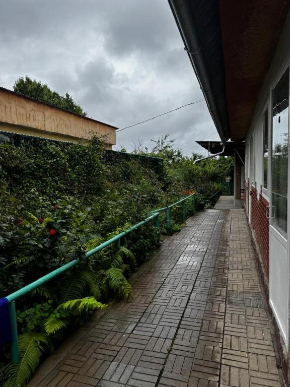 a brick walkway next to a building with plants at Сакура in Cholpon-Ata