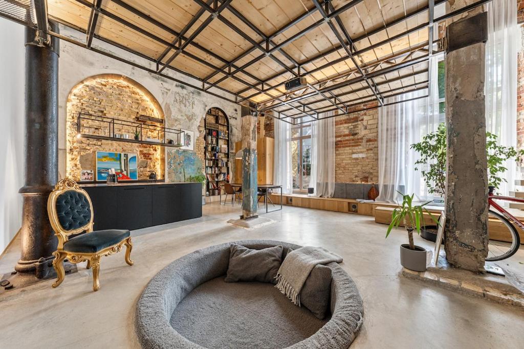 a large room with a couch and a chair in it at Raw Luxury Loft in Vilnius in Vilnius