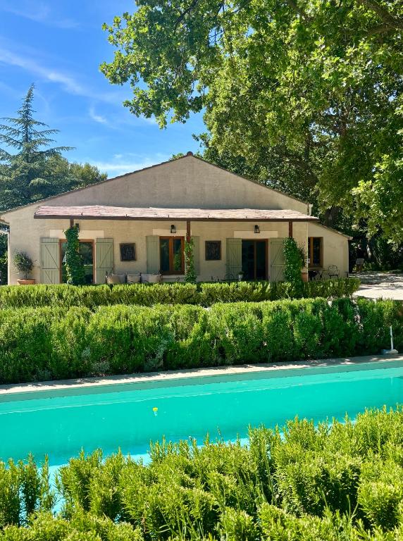 a house with a swimming pool in front of it at La Villa Bohème Piscine Jardin Vue Luberon in Oppède