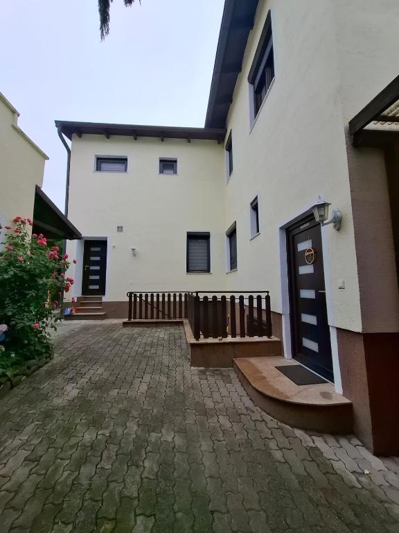 a white building with a door and a brick courtyard at Apartments Nicole in Baden