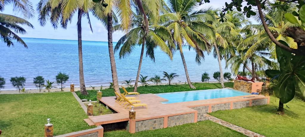 a swimming pool with palm trees and the ocean at Maeva Beach in Sainte Marie