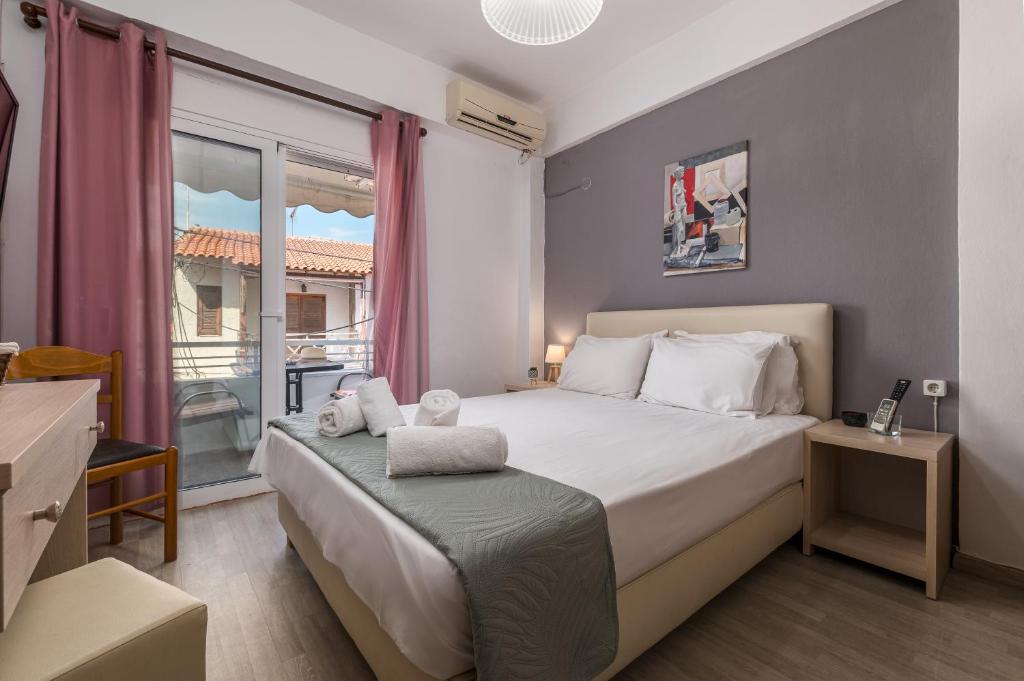 a small bedroom with a bed and a window at ΤΗΕRAMVOS in Pefkochori