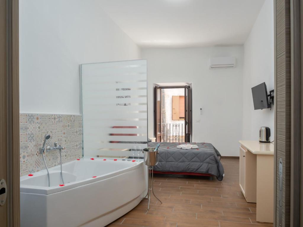a bathroom with a bath tub and a bed at B&B La Via dei Mulini in Corigliano Calabro