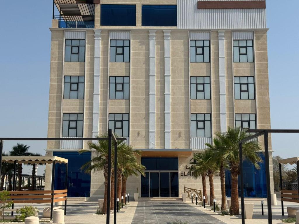 a building with palm trees in front of it at فندق ايلانا بلس in Farasan