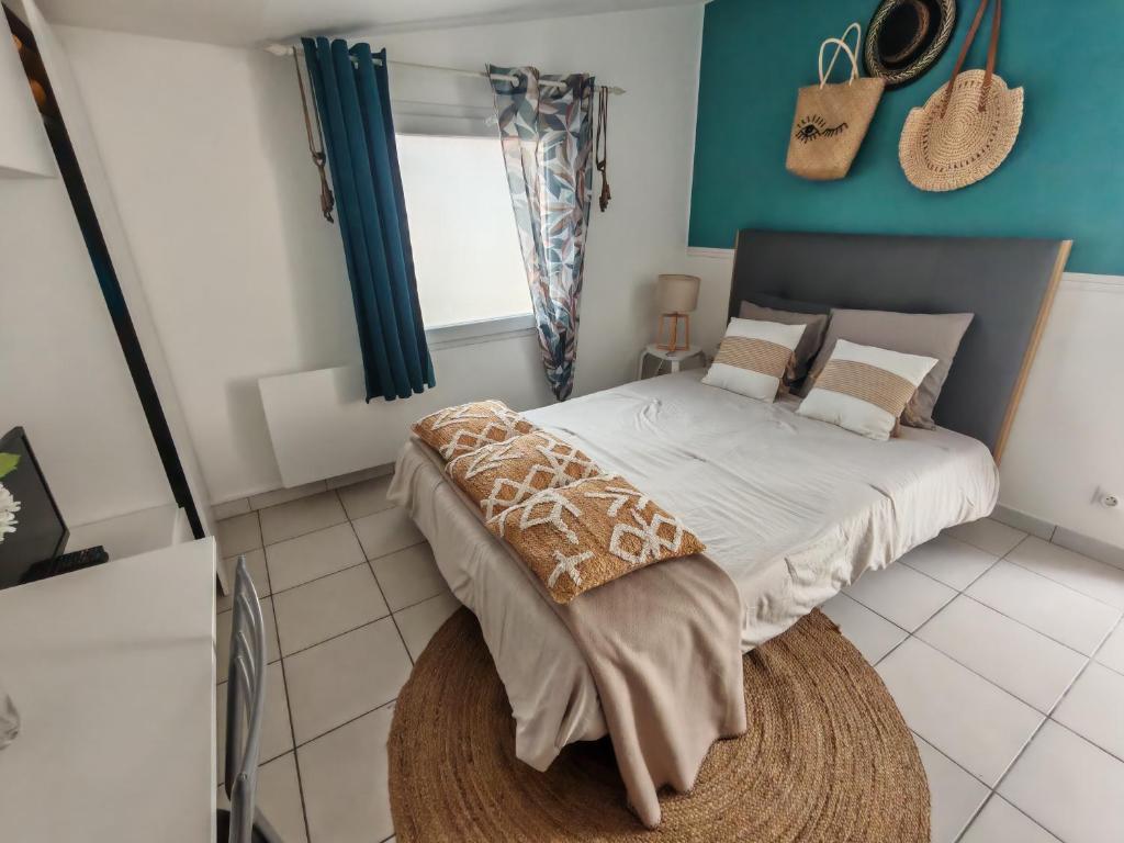 a bedroom with a large bed with a blue wall at Studio pour 1 ou 2 personnes in Le Landreau