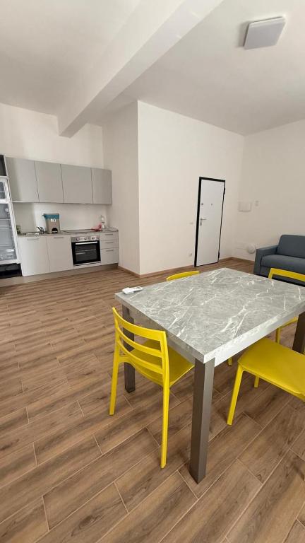 a table and two yellow chairs in a room at Apppartamenti La Fiorentina 609 in Gagno