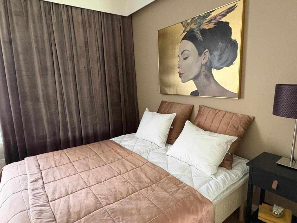 ein Schlafzimmer mit einem Bett und einem Gemälde an der Wand in der Unterkunft Guesthouse Terkkari in Lahti