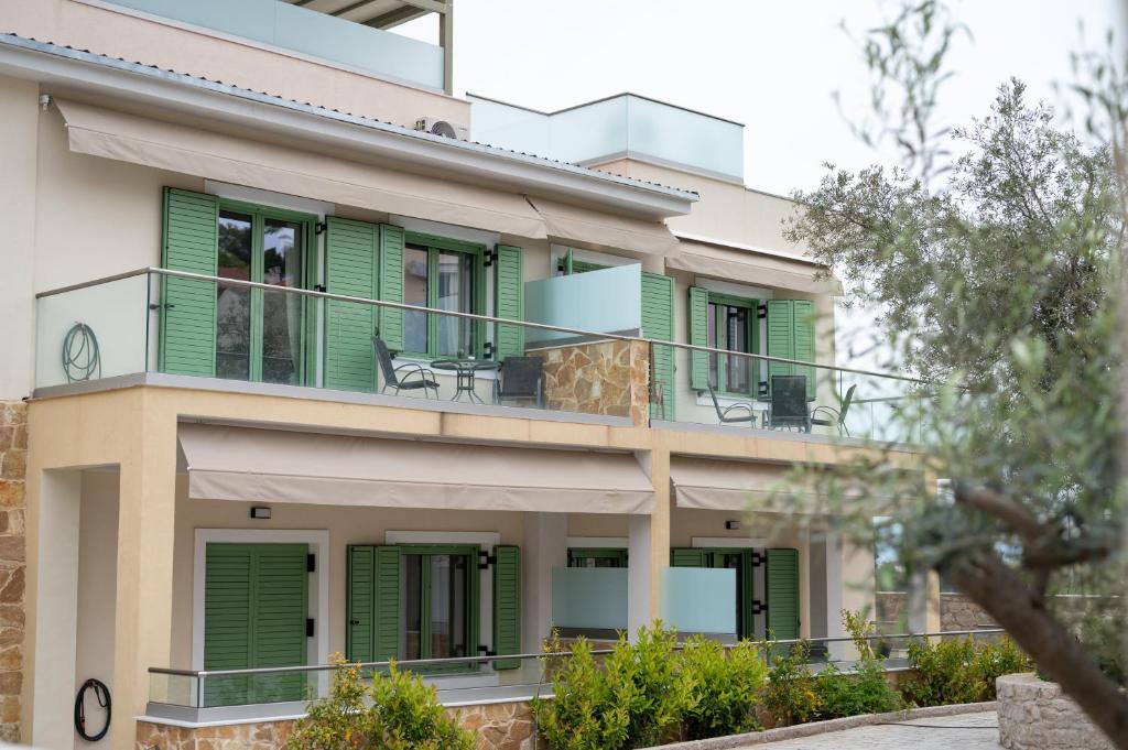 a house with green shutters and a balcony at Asini deluxe suite 1, with rooftop terrace and breathtaking views in Asíni