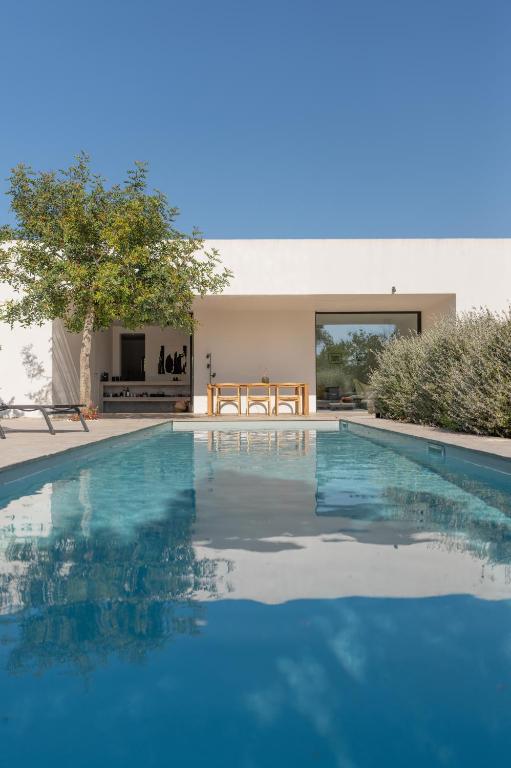 a swimming pool in front of a house at Casa Pavone in Carovigno