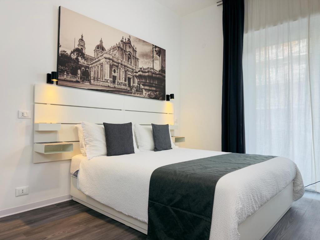 a bedroom with a bed with a picture on the wall at Aulino House in Catania