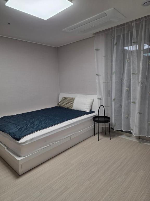 a white bedroom with a bed and a table at 청라 스테이 22층 뷰 공항 송도 검단 김포 in Kojan