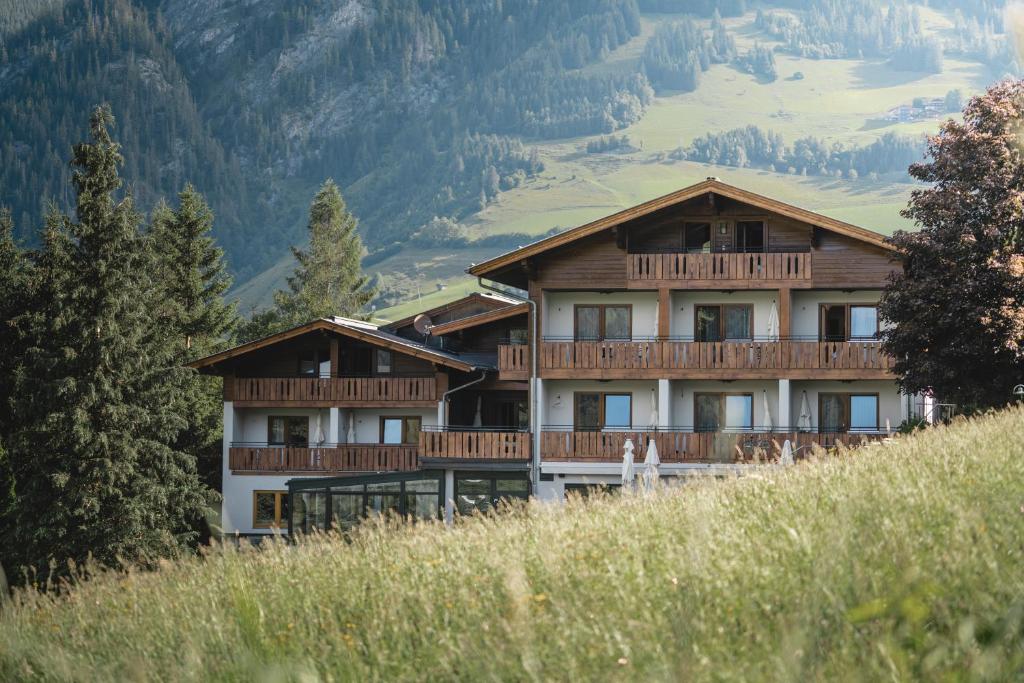 a large building on top of a hill at Genusshotel Fichtenhof in Grossarl