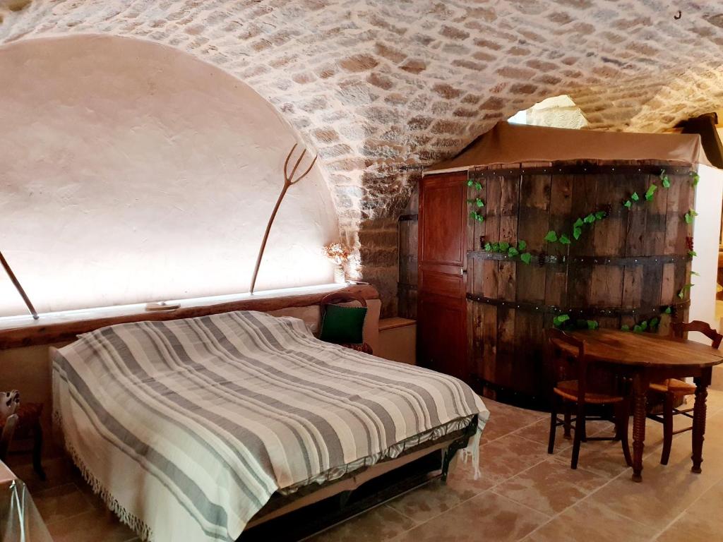 a bedroom with a bed and a desk and a table at Studio l'envoûté in Saint-Rome-de-Tarn