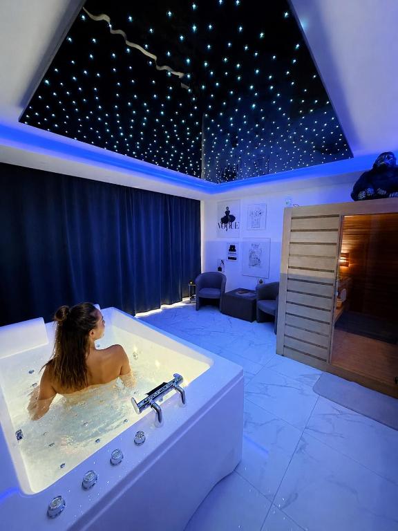 a woman in a bath tub in a room at Cozy Rental SPA in Schiltigheim