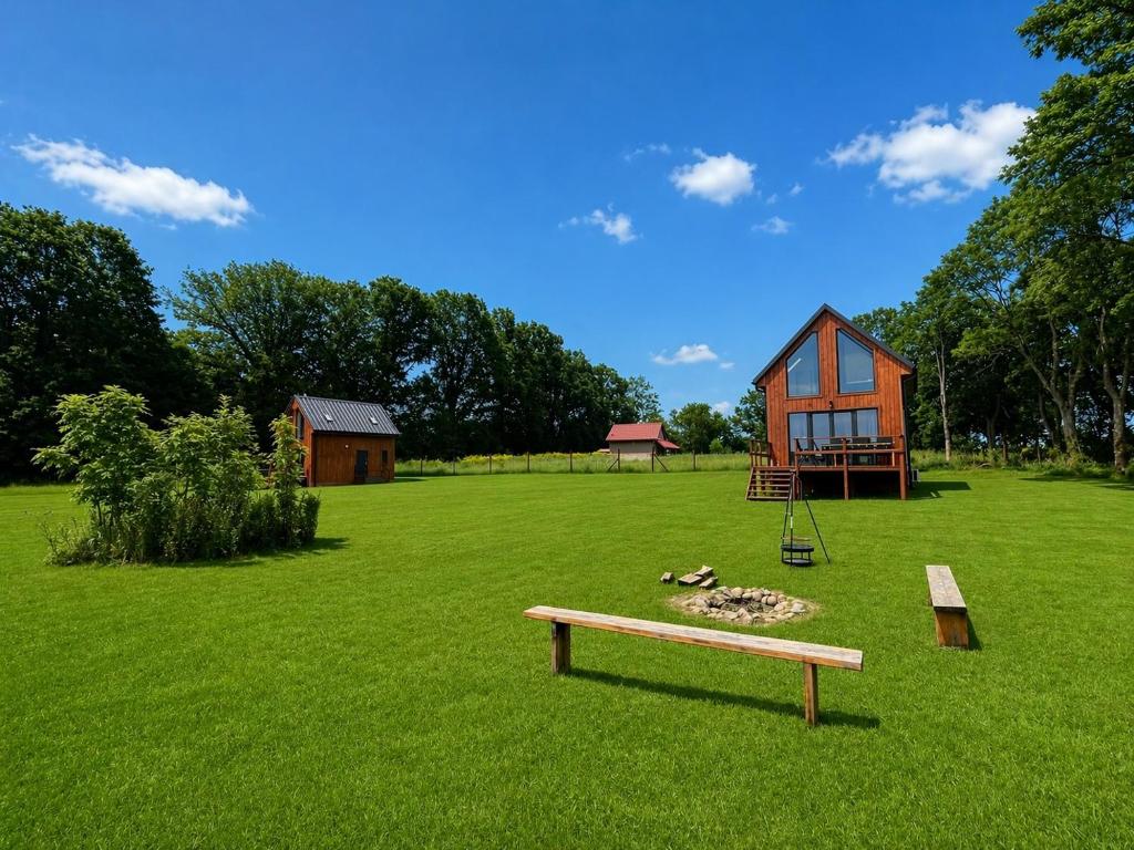 a bench in a field with a house and a playground at Domki u Gąski in Gąsiorowo Olsztyneckie