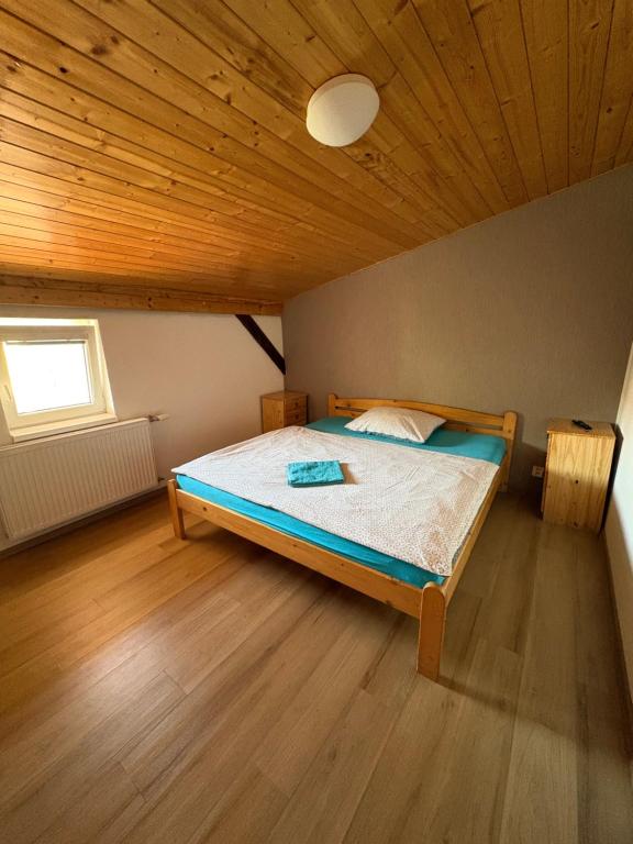 a bedroom with a bed with a wooden ceiling at Penzion U Martina in Mariánské Lázně