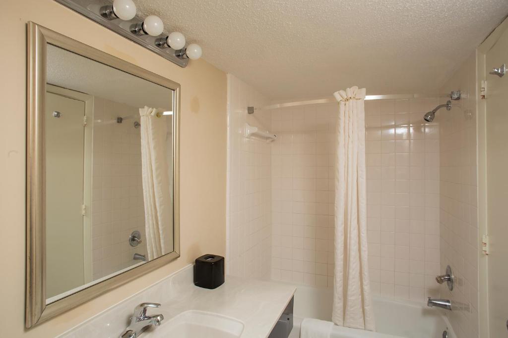 a bathroom with a sink and a shower with a mirror at Grande Shores in Myrtle Beach