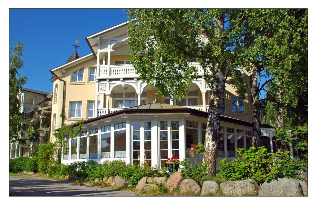 a large yellow building with white trim at Hotel Villa Granitz in Baabe