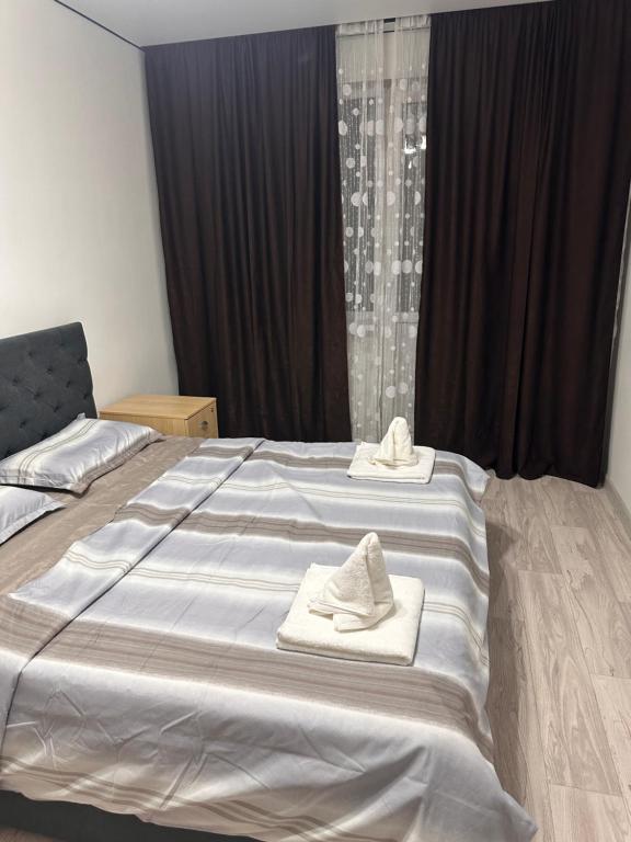 a bedroom with a large bed with towels on it at 7 Su Nury in Almaty