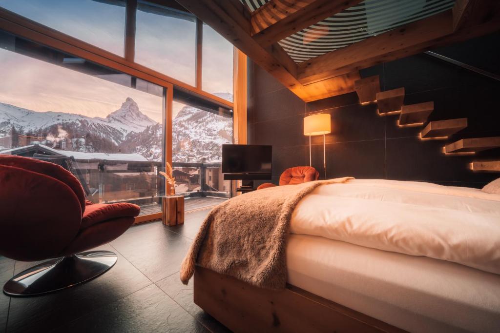 a bedroom with a bed and a view of a mountain at Hotel Bellerive in Zermatt