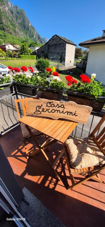 a wooden bench sitting on a patio with flowers at Casa Vacanza GERONIMI in San Cassiano